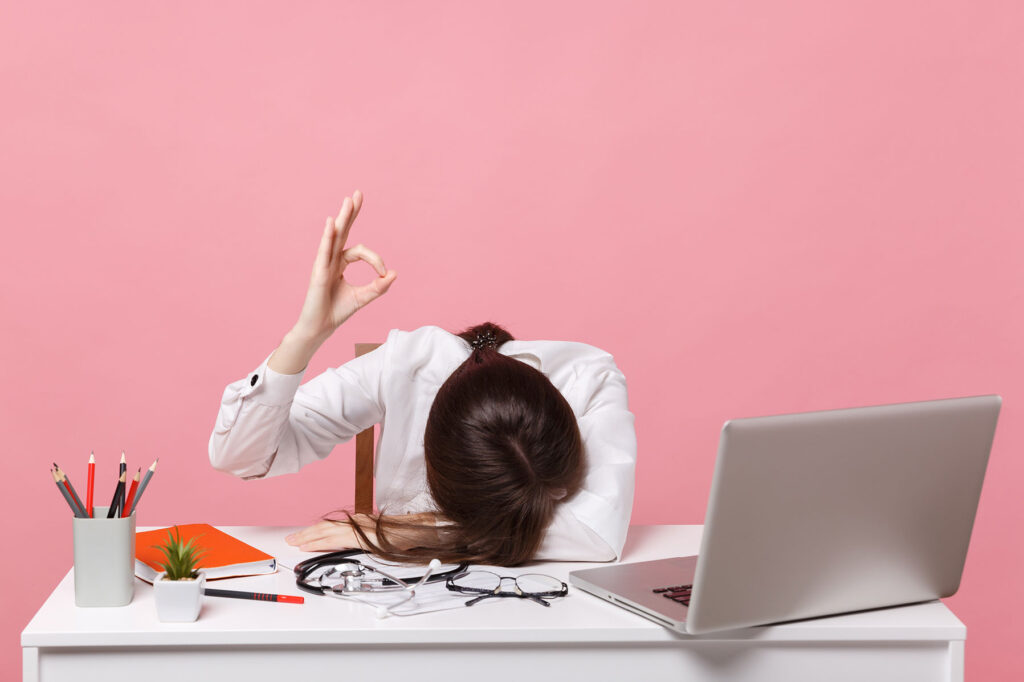 Female doctor with head on desk