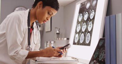 Doctor texting results of brain scans