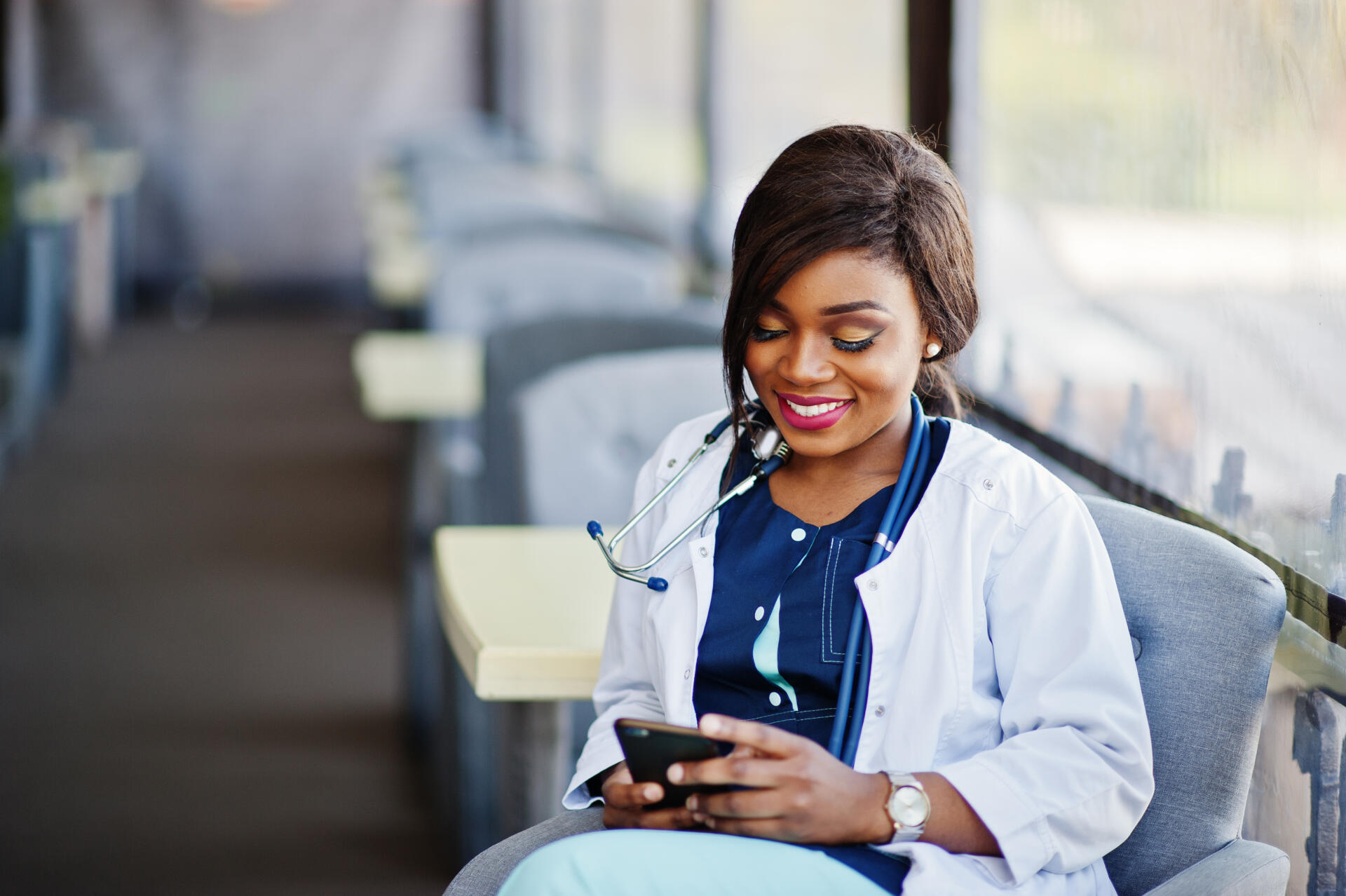 female doctor with stethoscope looking at phone