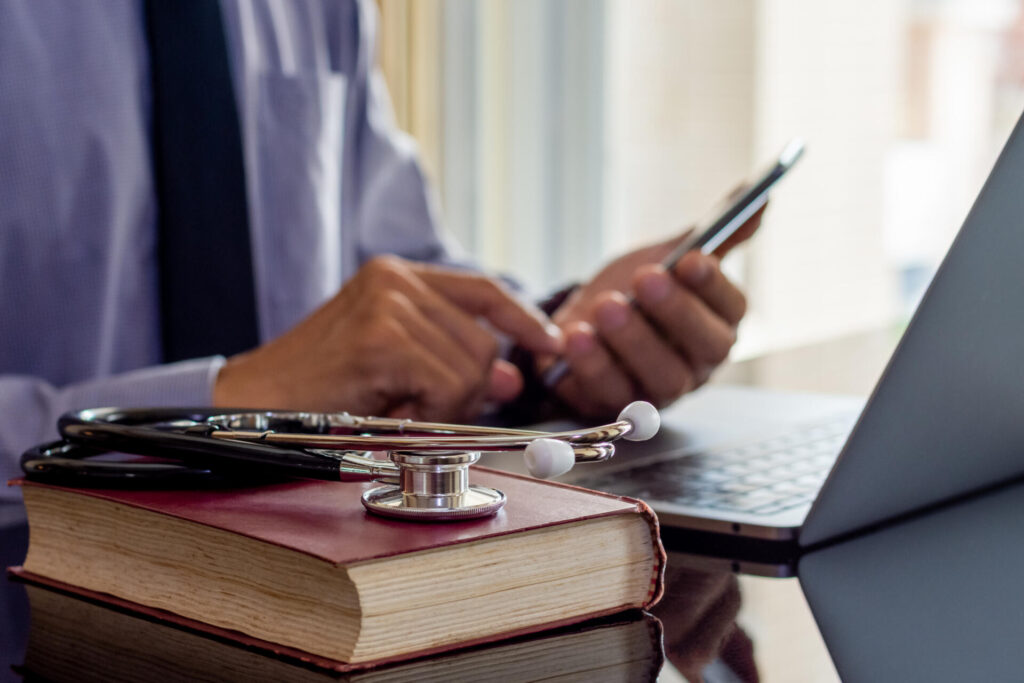 Male doctor hand holding and using mobile smart phone