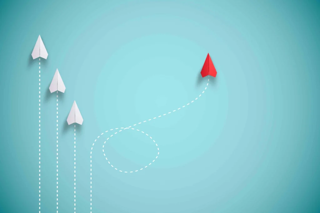 Red paper plane out of line with white paper to change disrupt and finding new normal way on blue background. Lift and business creativity new idea to discovery innovation technology.