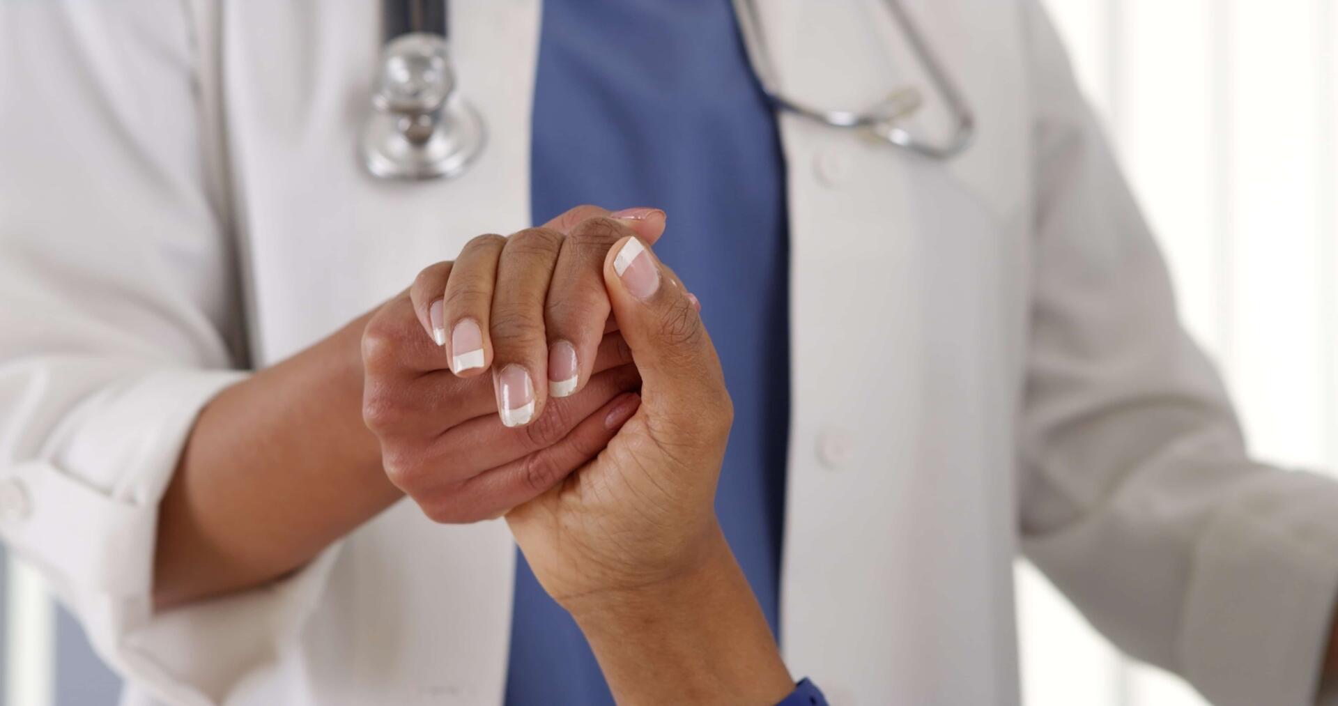 Close up of female doctor holding patient's hand