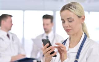 Female Doctor using Smartphone in Office