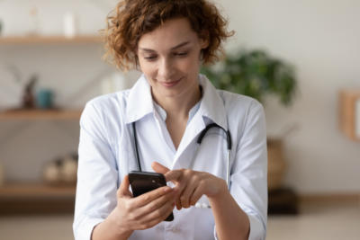 Young female physician using mobile app